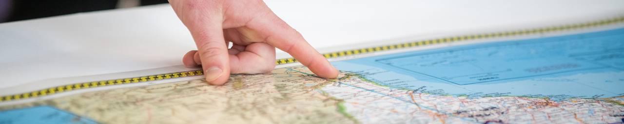 Hand pointing at a map